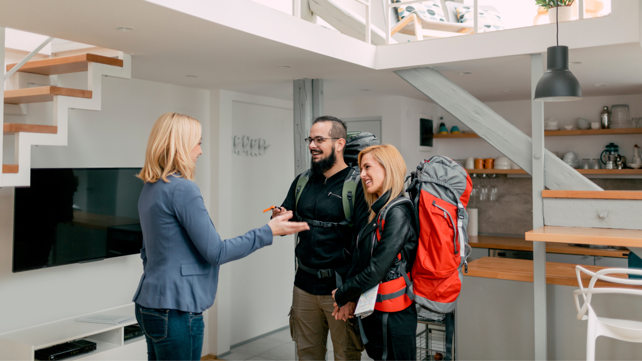 Photo of a host greeting two Airbnb guests, symbolizing Jurny helping property managers overcome the top 10 challenges with AI-driven solutions.