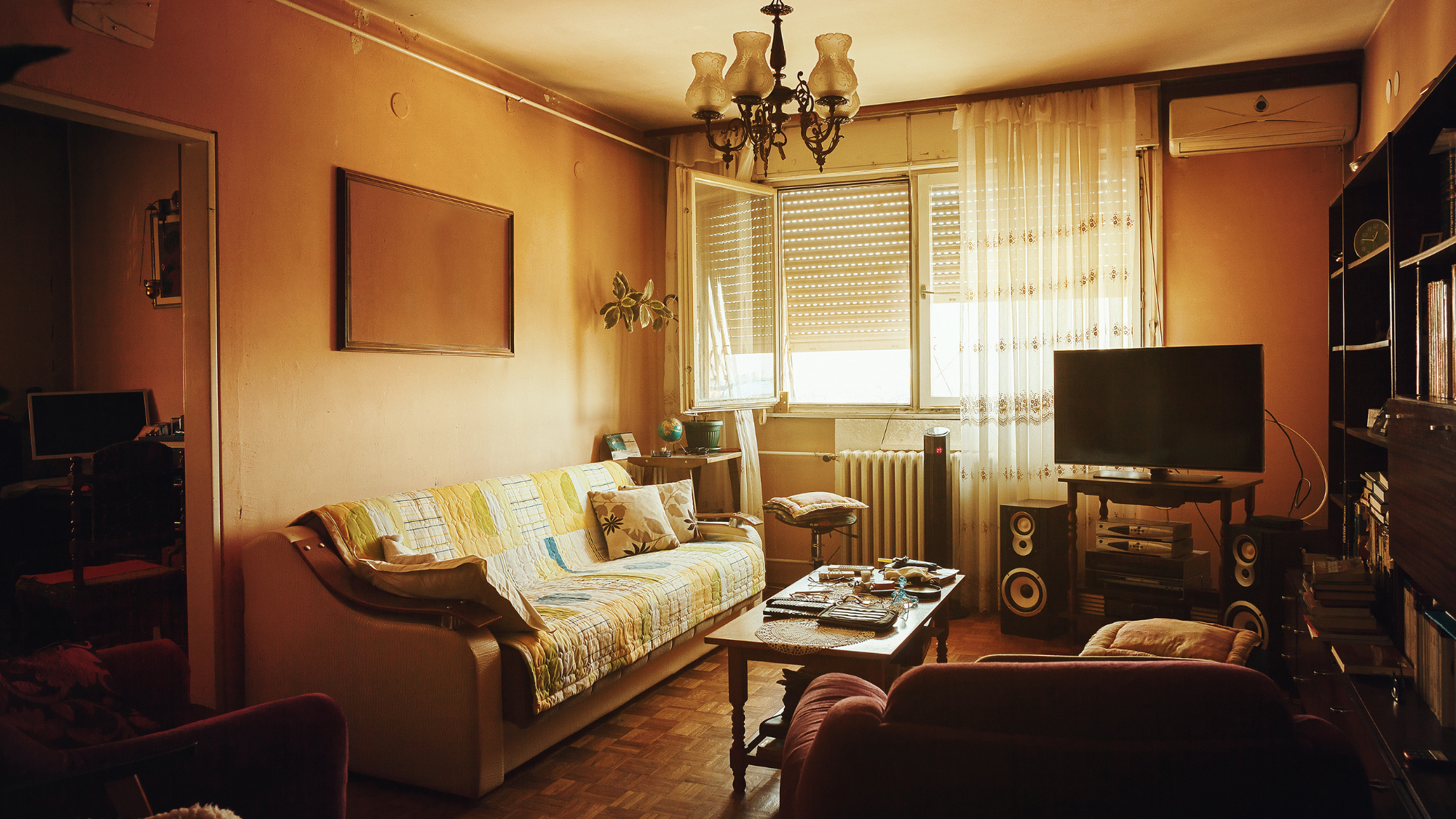 Airbnb listing photo example of a cozy living room with sofa, TV, coffee table, and window light