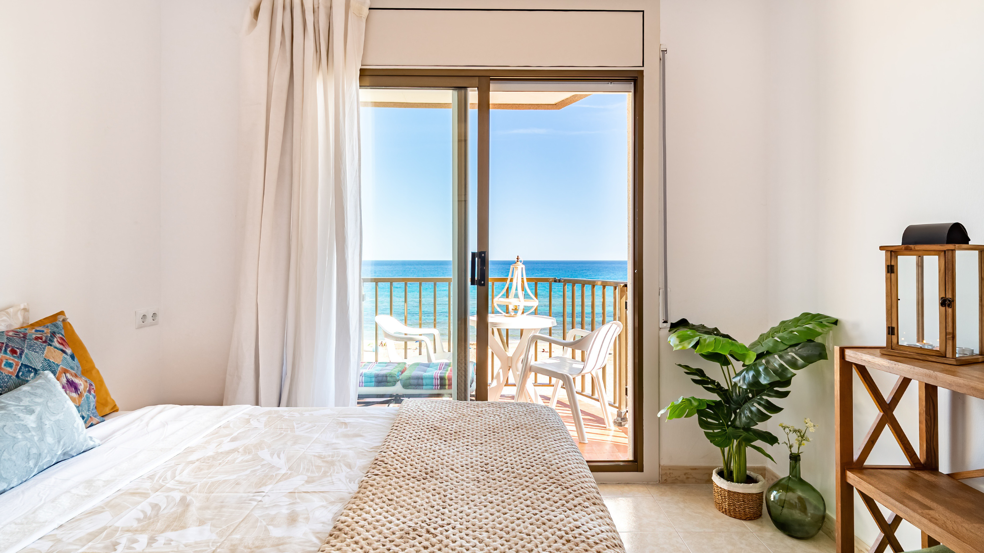 Ocean-view beach rental bedroom with balcony—ideal for promoting beach stay upsells and add-ons.
