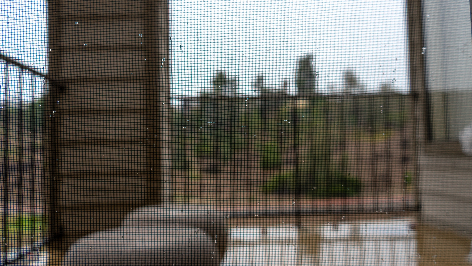 Blurred view of a rainy day from a balcony, illustrating how bad weather affects the vacation rental guest experience.
